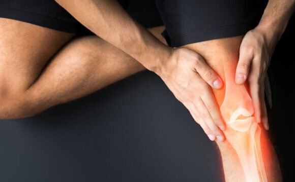 Orthopedic surgeon examining a patient's knee joint."