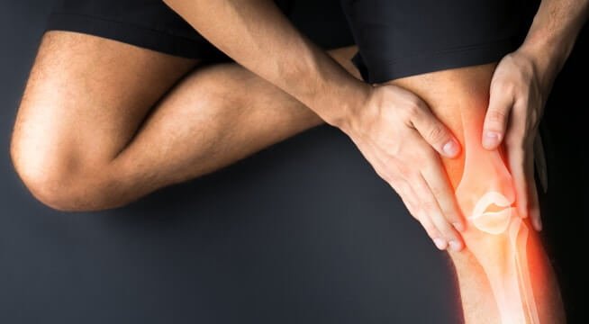 Orthopedic surgeon examining a patient's knee joint."