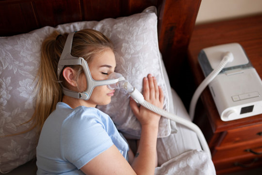 Individual sleeping with a CPAP mask to treat sleep apnea.